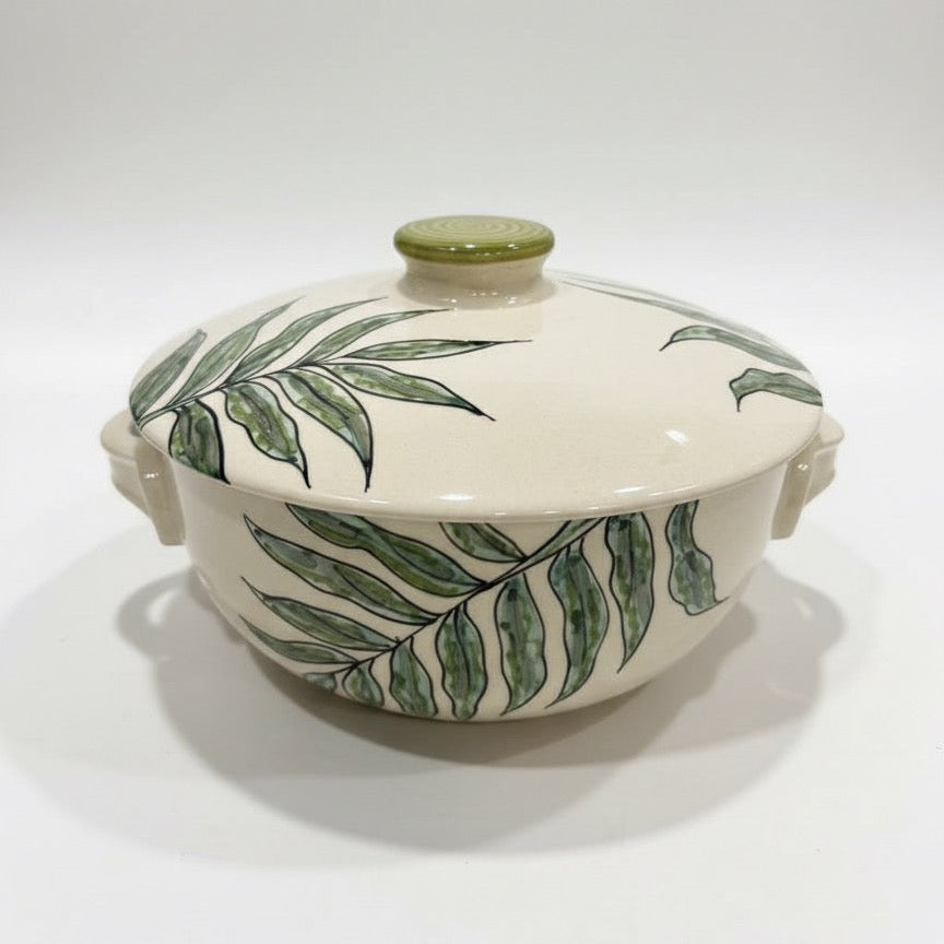 Handcrafted floral leaf ceramic serving casserole with side handles and round lid.